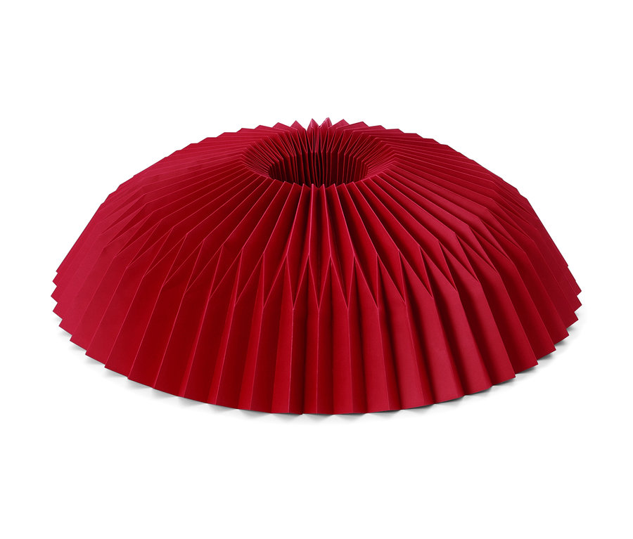 Egy piros papír karácsonyfatalp takaró.