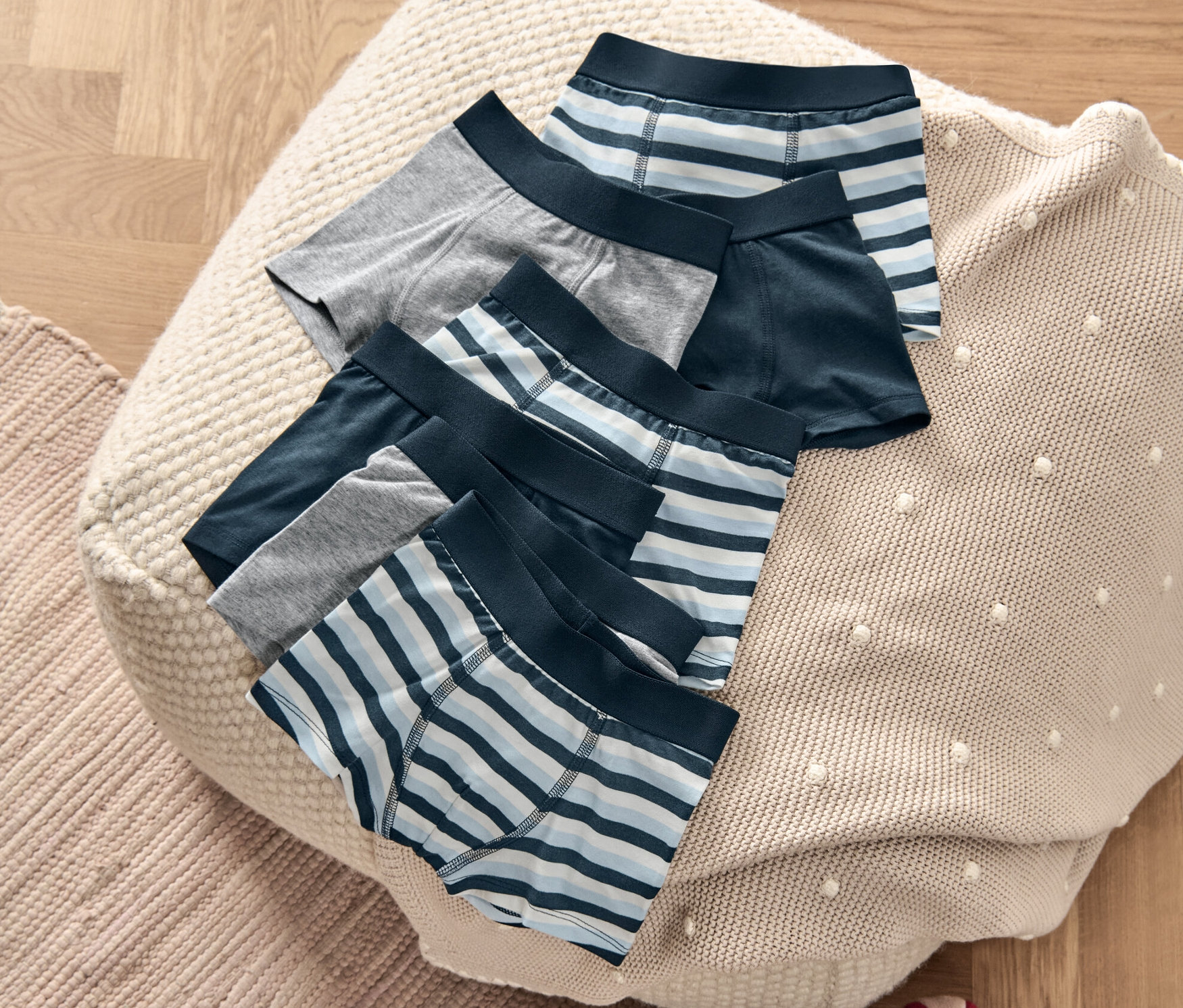 Hét fiú boxer alsó fekszik egy puffon egy gördeszka mellett.