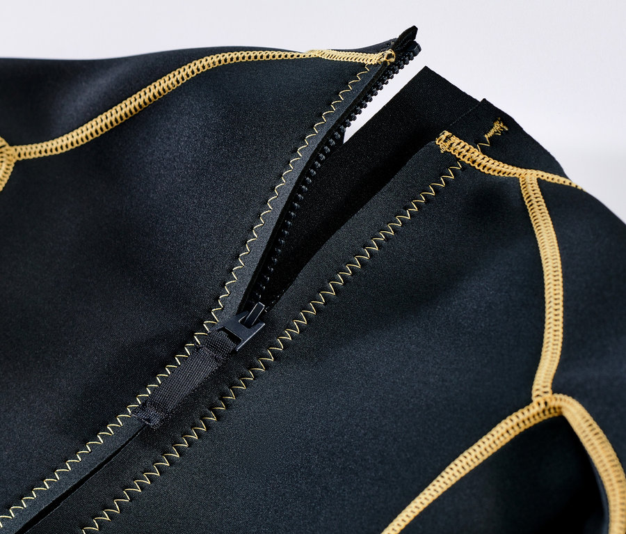 Egy fekete gyerek neoprénruha részlete, nyitott cipzárral és sárga szegéllyel.