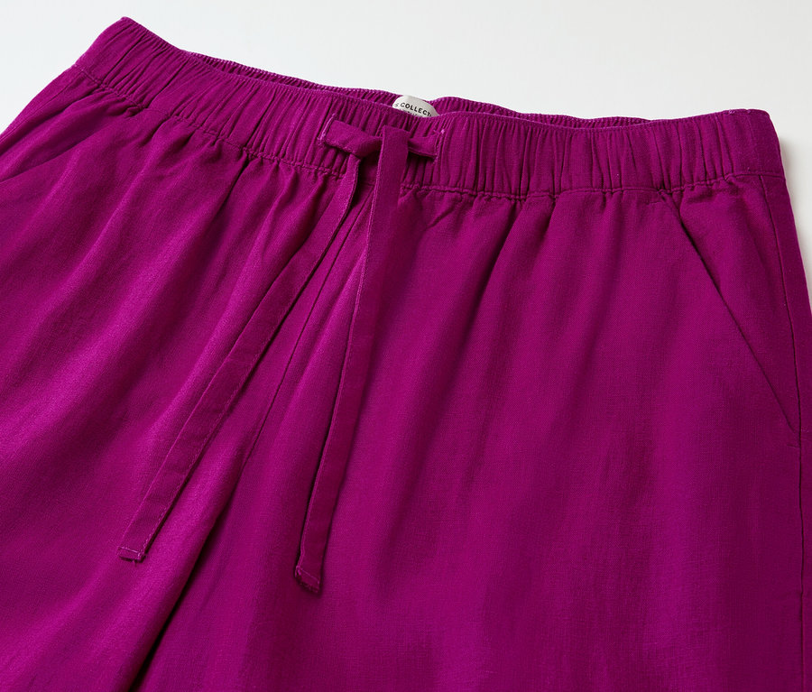 A fukszia színű, lenvászon női lezser nadrág részlete, gumis derékpánttal és húzózsinórral.