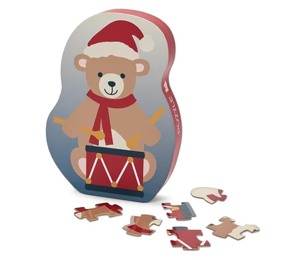 Egy doboz puzzle, amelyen egy dobos, télapósapkás medve és hat puzzle-darab látható.