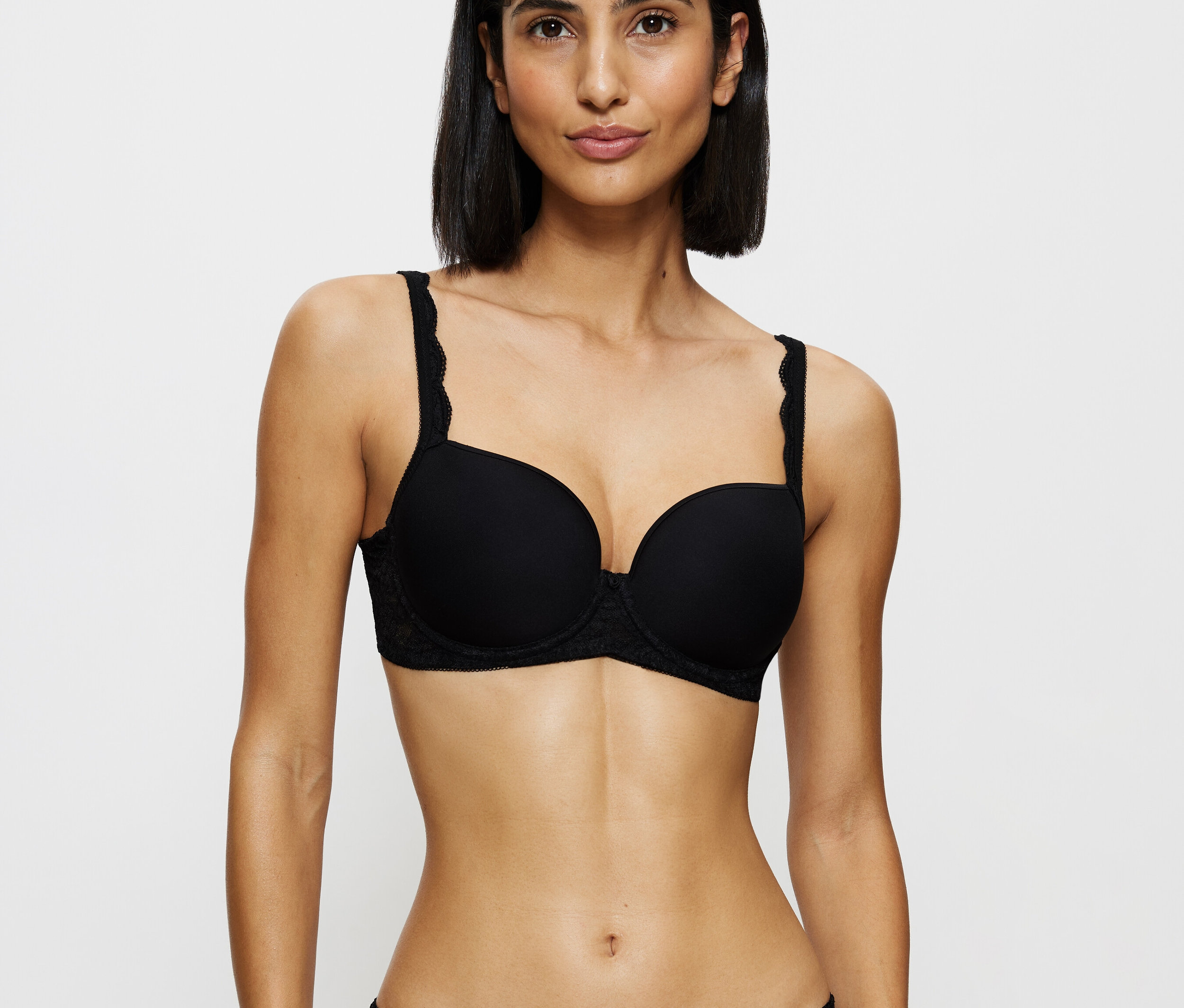 Nő fekete csipkés melltartót és bugyit visel.
