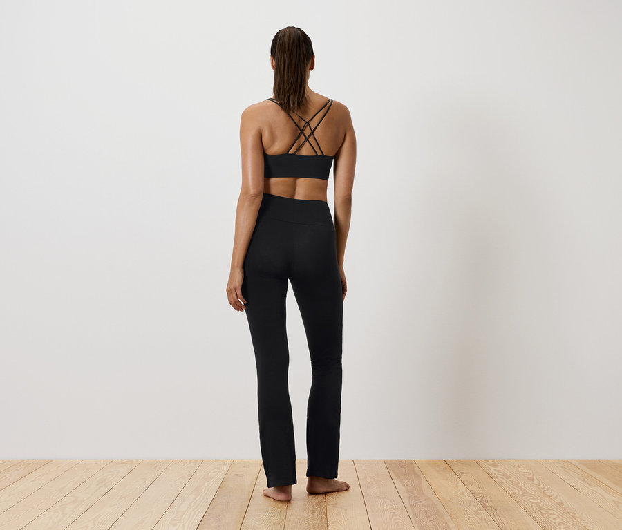 Nő fekete sportruházatban, hátulról.