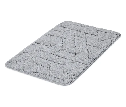 Egy szürke, geometrikus mintázatú szőnyeg fekszik egy fehér háttéren.