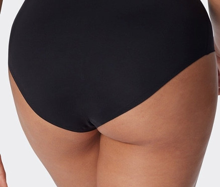 Közeli kép egy fekete alsóneműt viselő nő hátsó nézetéről.