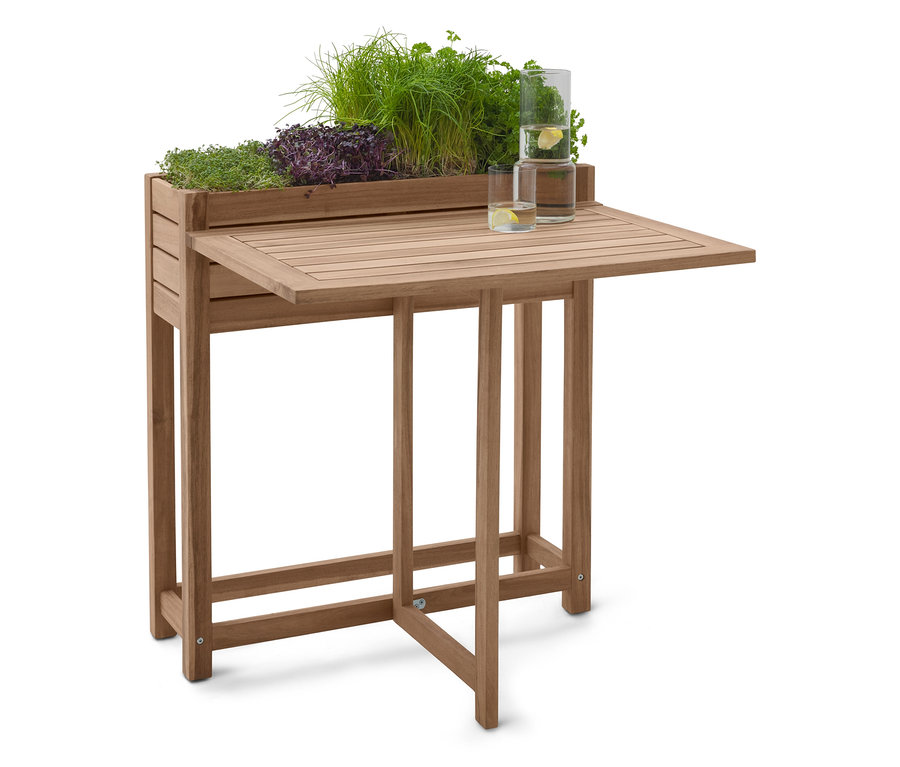 Fából készült ültetőasztal gyógynövényekkel és két pohár vízzel.