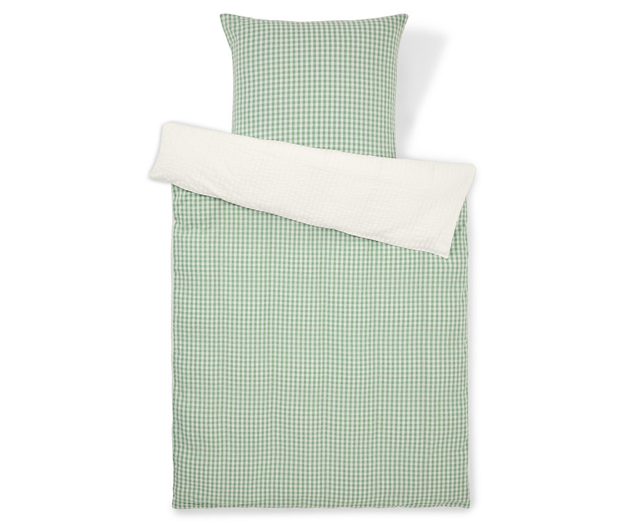 Ágynemű szett zöld-fehér kockás mintával és fehér párnahuzattal, felülről fényképezve.