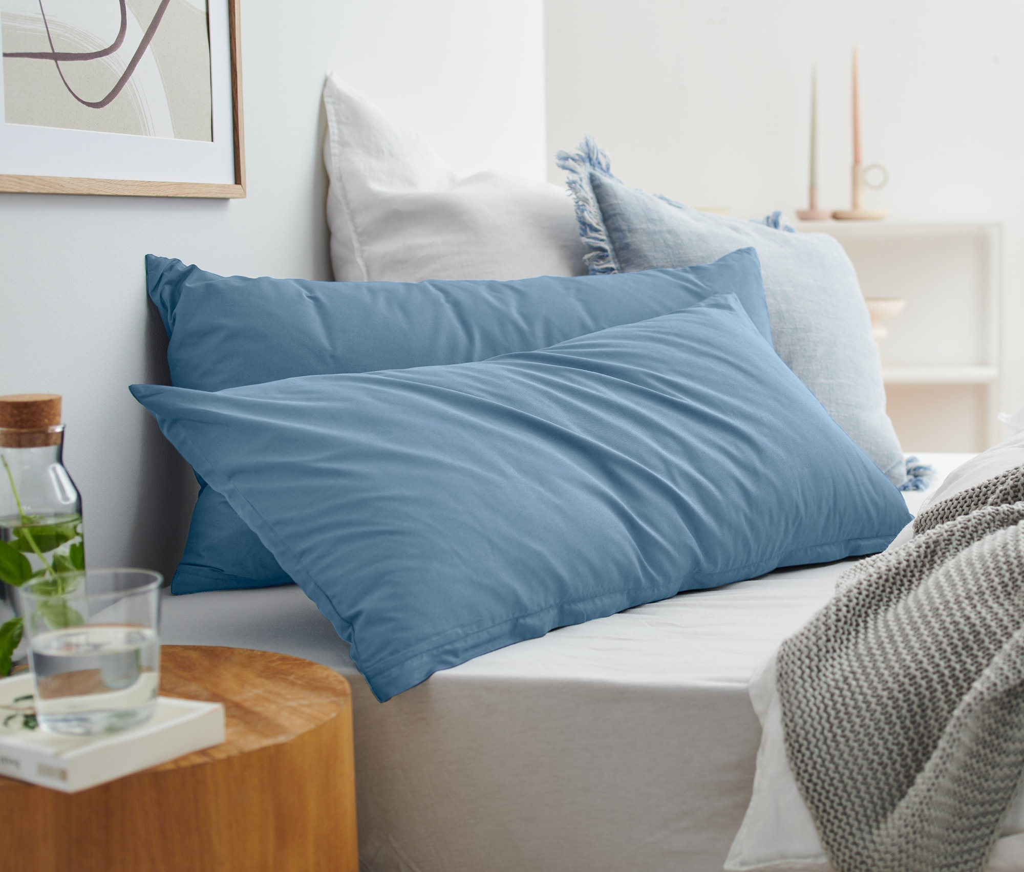 Az ágyon két kék színű, renforcé párnahuzat látható.