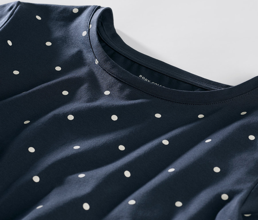 Egy sötétkék, pöttyös pizsama részletének közeli képe.