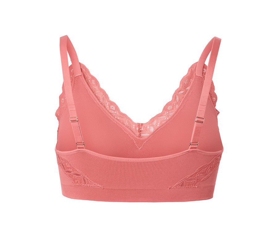 Közelkép egy korall színű, csipkés szegélyű, női seamless bustier melltartóról.