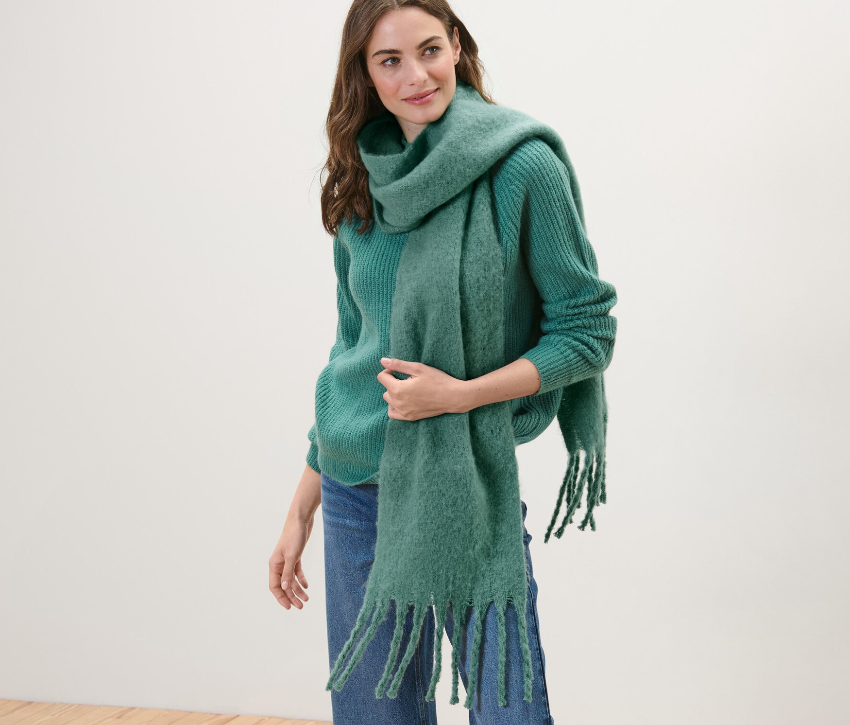 Nő visel zöld kötött pulóvert és szövött sálat, zöld.