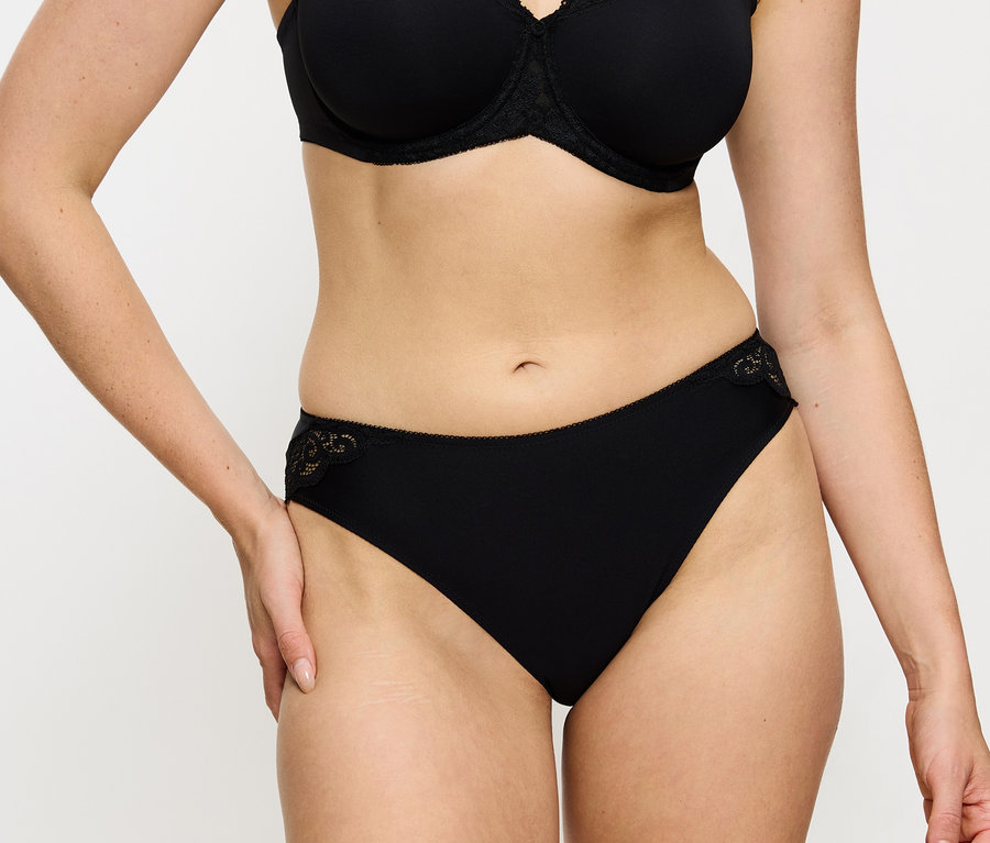 Nő visel fekete melltartót és Triumph Amourette Tai alsót, fekete színben.