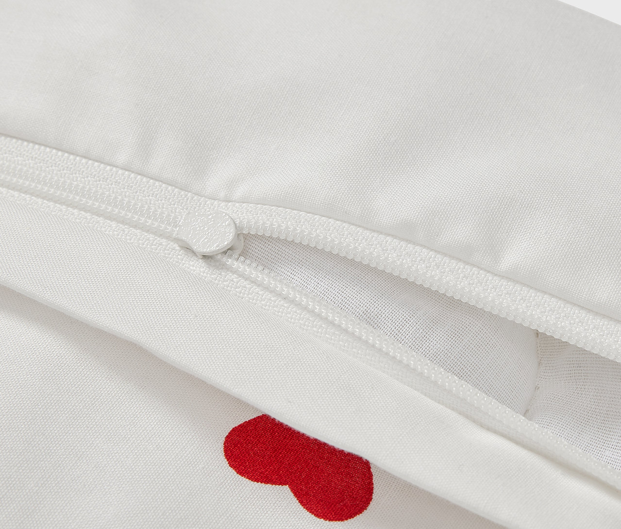 A 100 x 135 cm-es renforcé gyerekágynemű részlete piros szívekkel és cipzárral.