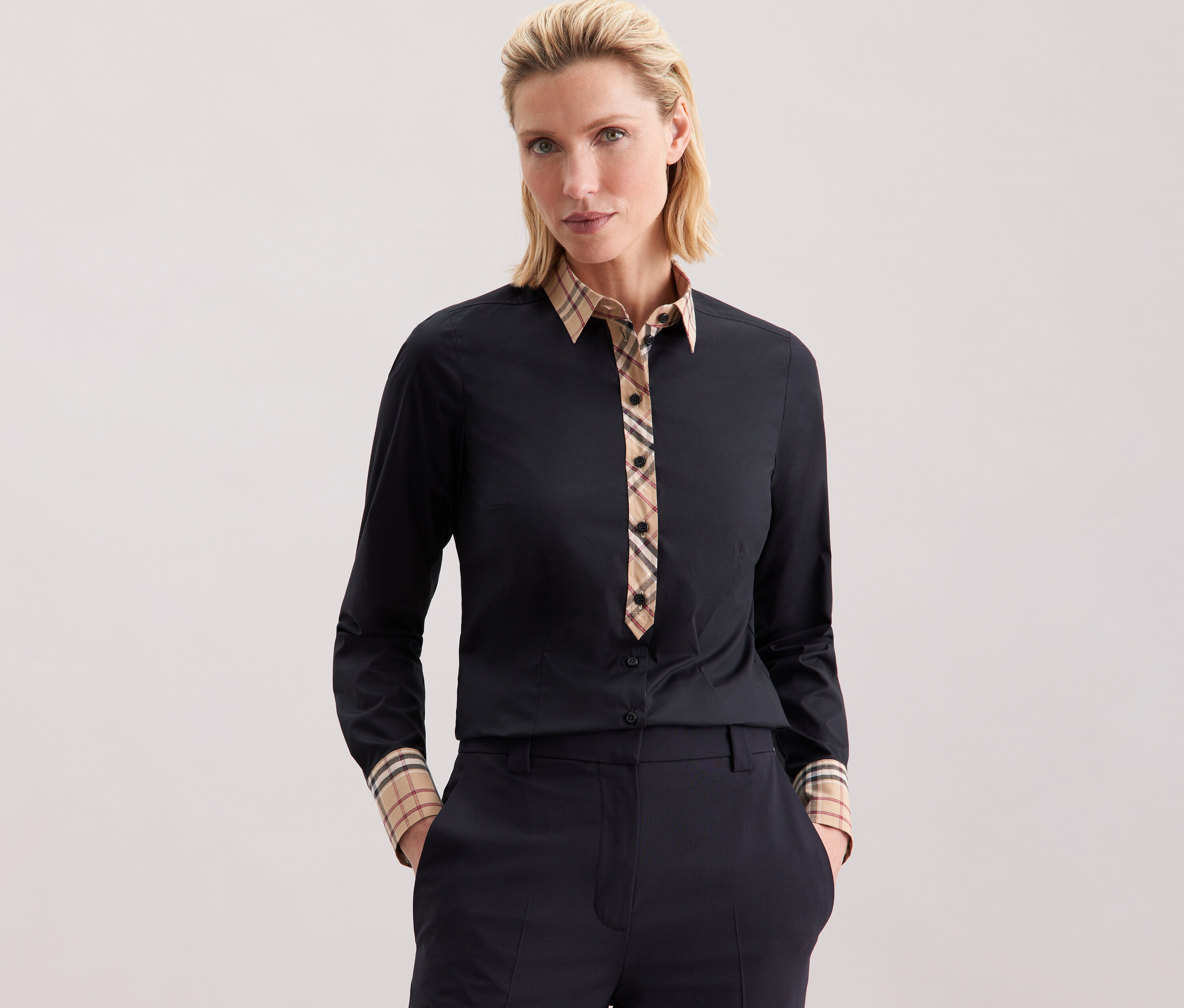 Nő visel Seidensticker poplin blúzt kockás elemekkel.