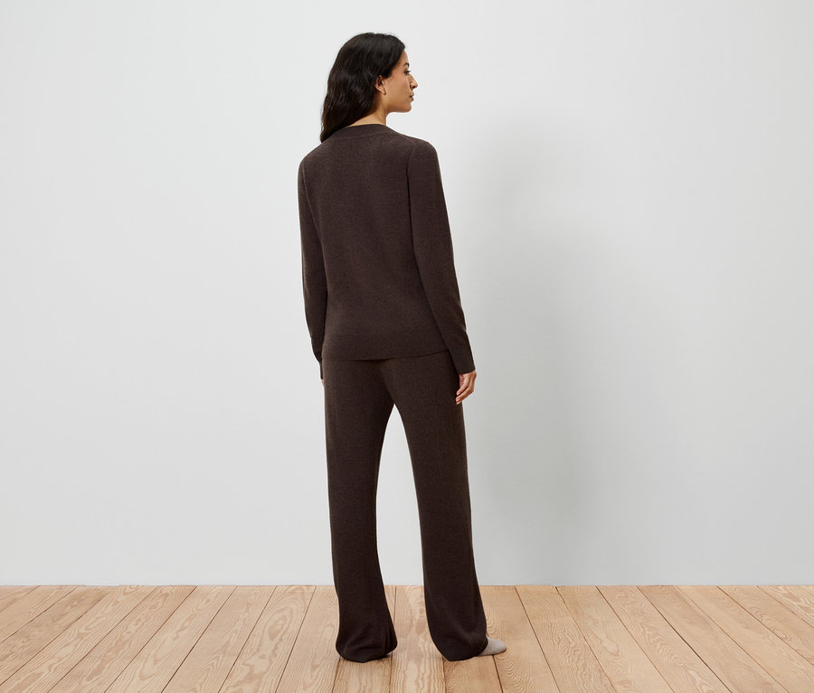 Hátulnézet egy barna kötött pulóvert és nadrágot viselő nőről.