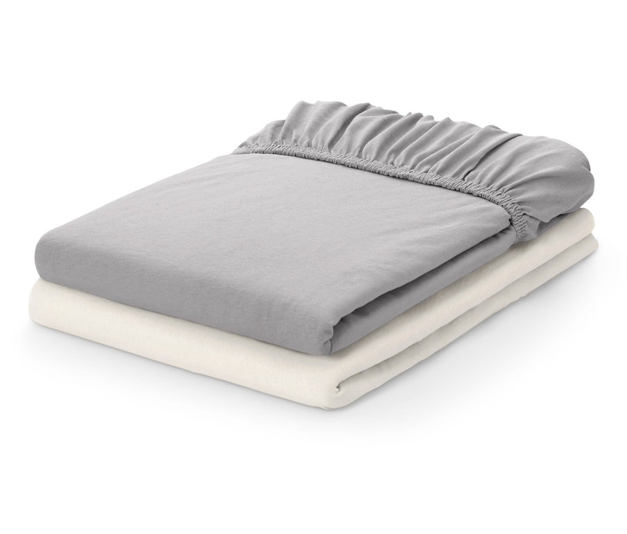 Két összehajtott lepedő: egy szürke és egy krémszínű.