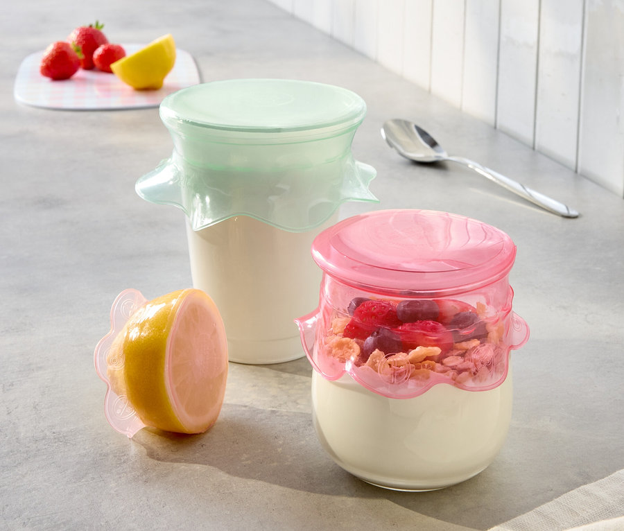 A konyhapulton két joghurtos üveg rózsaszín és menta színű fedővel, valamint egy fél citrom rózsaszín fedővel.
