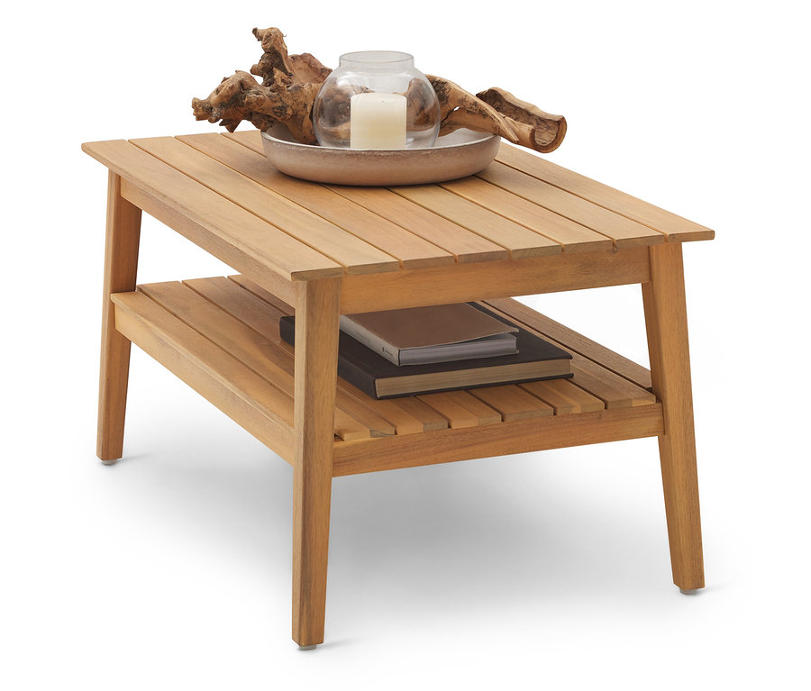 Egy világosbarna fa dohányzóasztal két szinttel. A felső szinten egy tál gyertyával és uszadékfával, az alsó szinten pedig könyvek találhatók.