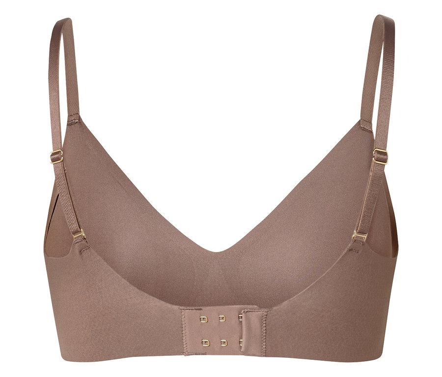 Egy bézs színű melltartó közeli képe, állítható pántokkal és hátul kapcsos rögzítéssel.