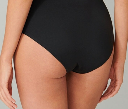 Hátulnézet egy fekete alsónadrágot viselő nőről.