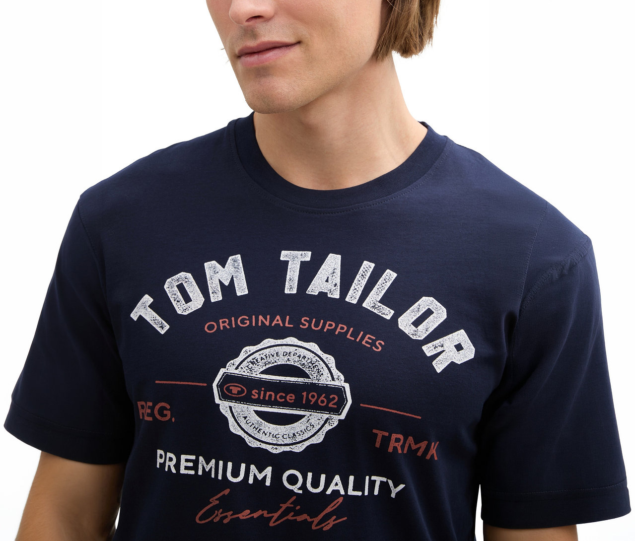 Férfi Tom Tailor pólót visel logóval, sötétkék színben.