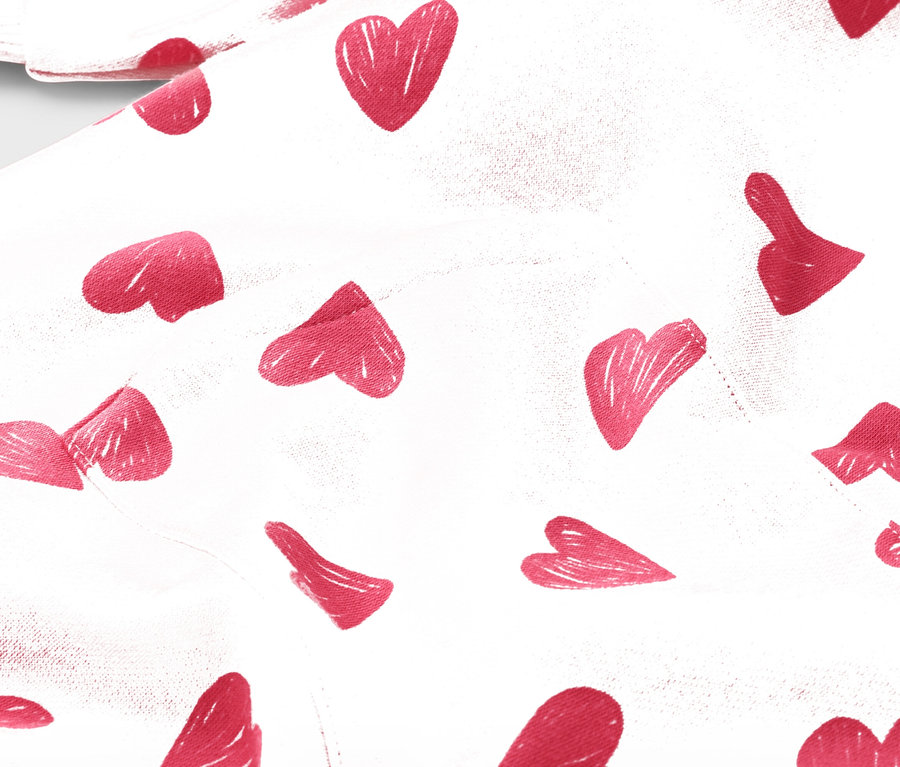 Egy fehér szövet közeli képe piros szívmintával.