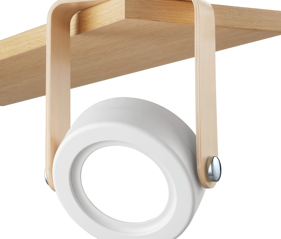 Egy összecsukható LED-es lámpa van egy fa polc aljára rögzítve.