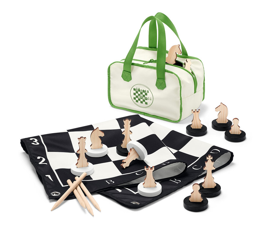 Egy XL-es sakkjáték van kiterítve fa sakkfigurákkal és egy táskával.
