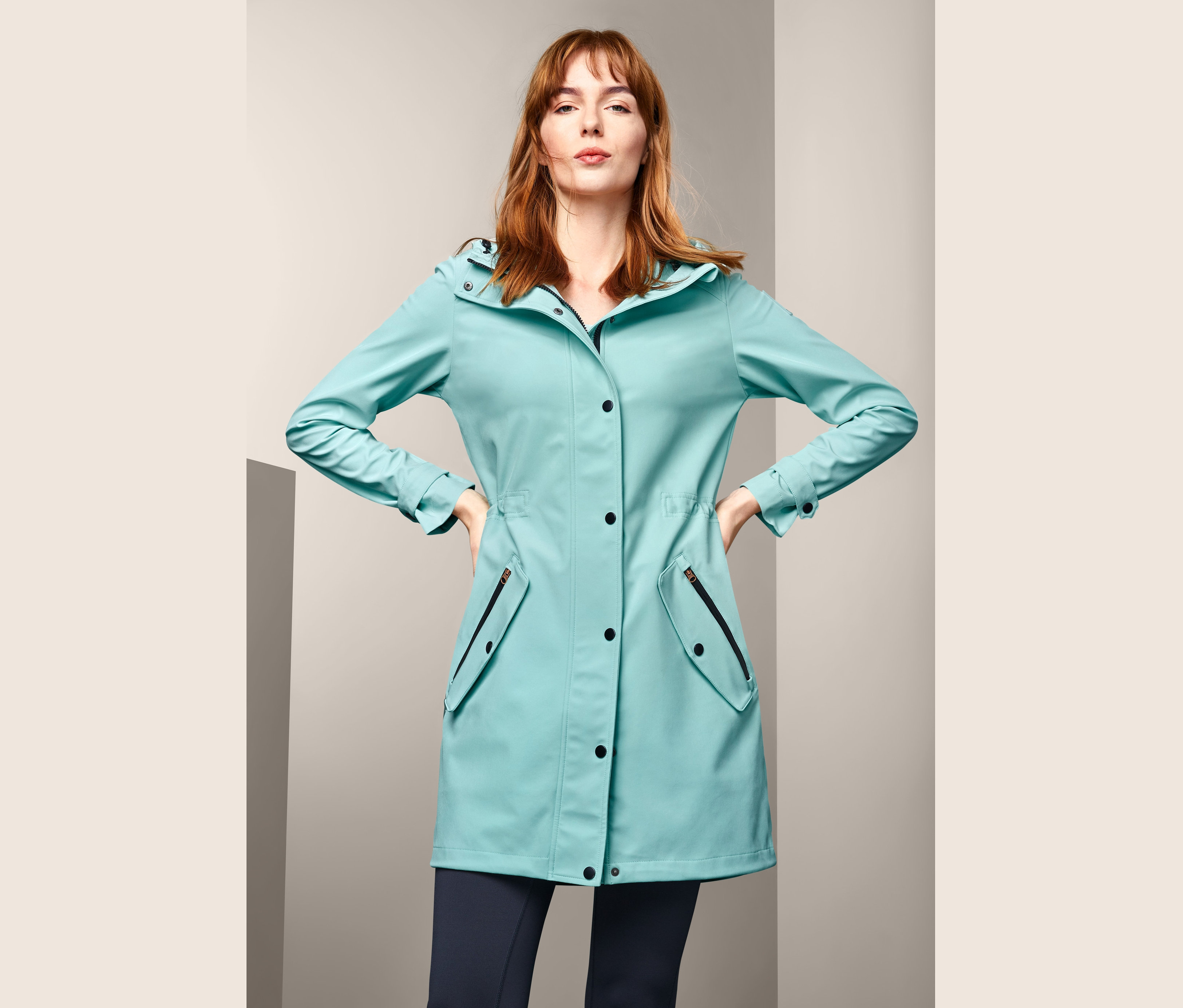 Nő pózol egy softshell kabátban.