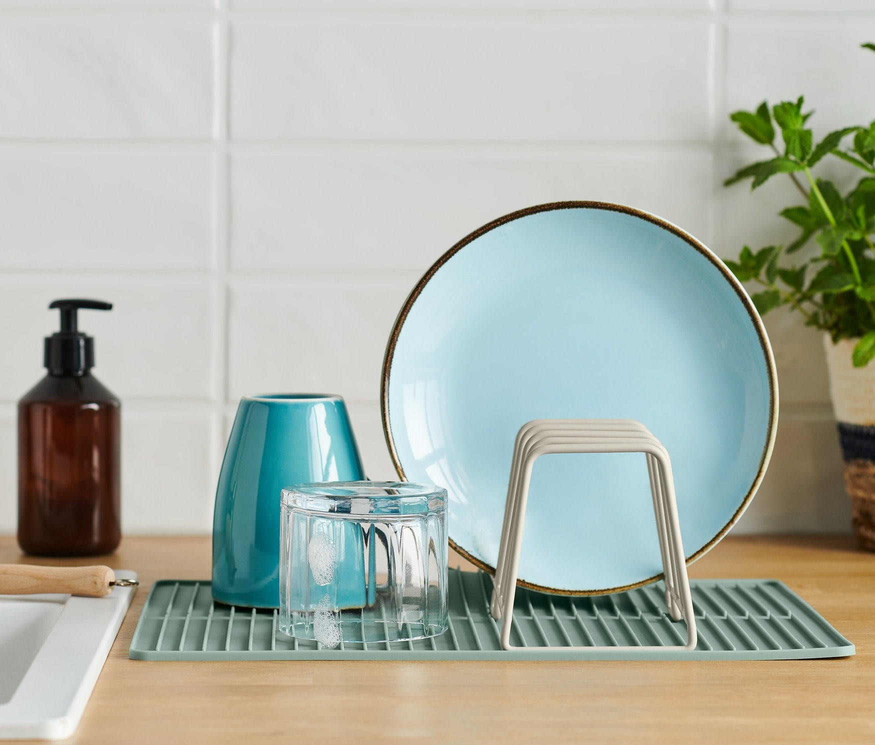 A konyhapulton edénycsepegtető rács található tányérral, pohárral és vázával.