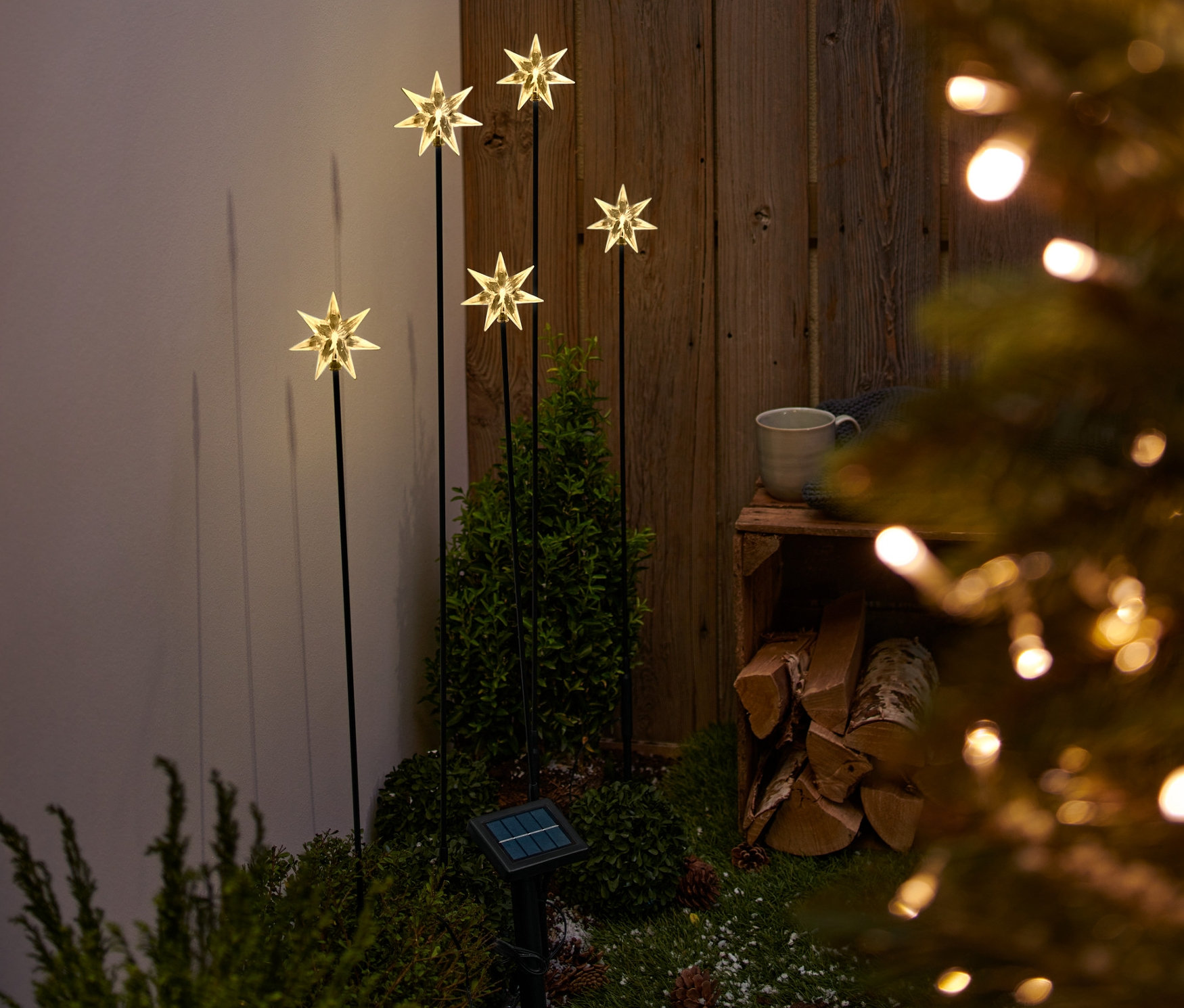 Öt napelemes csillag alakú lámpanyárs a kertben.