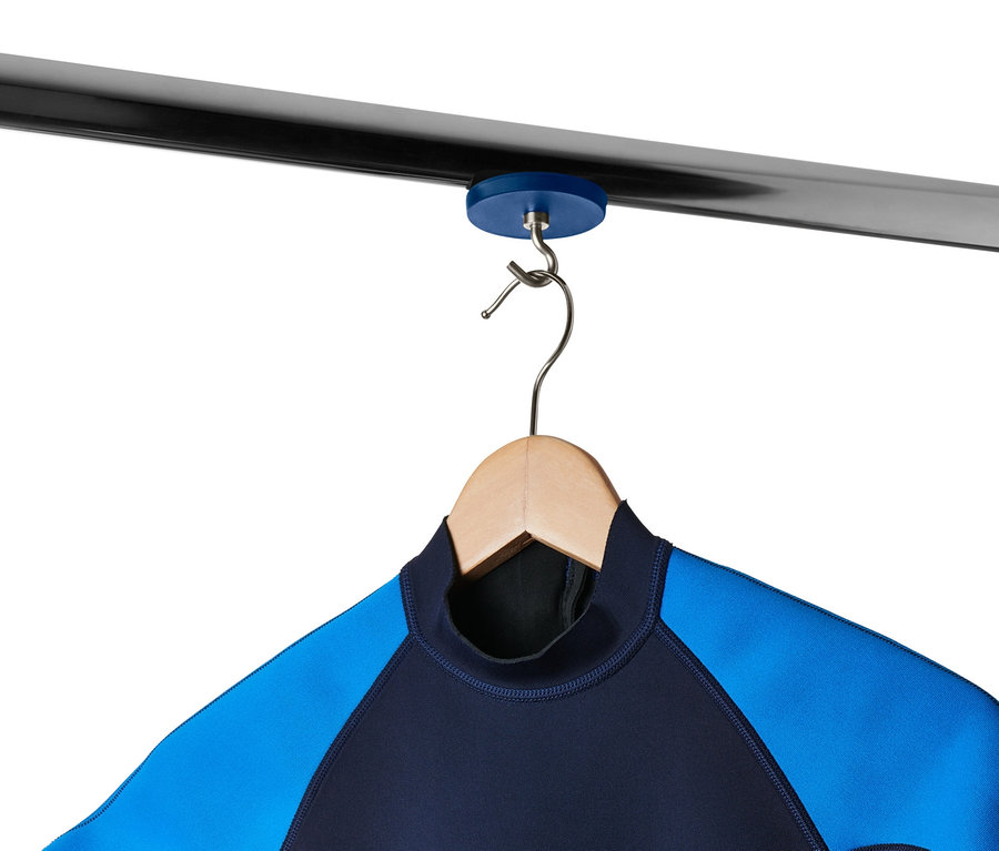 Kék-fekete neoprén ruha lóg egy fa vállfán, amely egy 2 mágneses akasztó szettben lévő mágneses akasztóval van egy fémrúdon rögzítve.