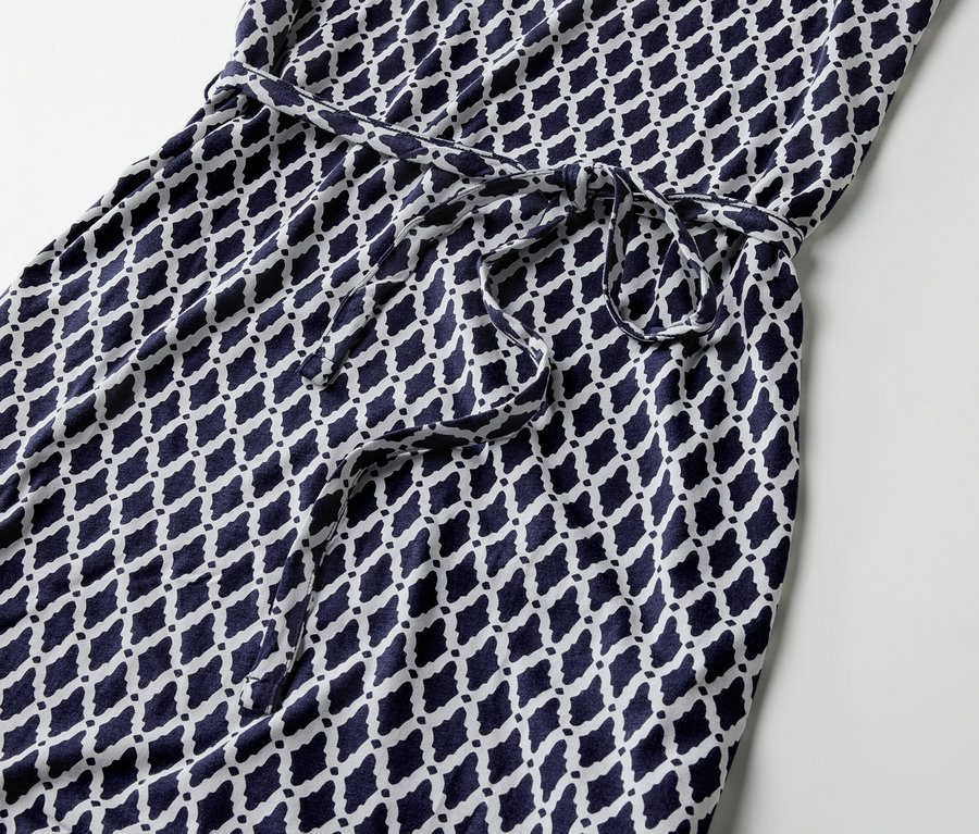 Mintás jersey ruha részlete megkötős övvel.