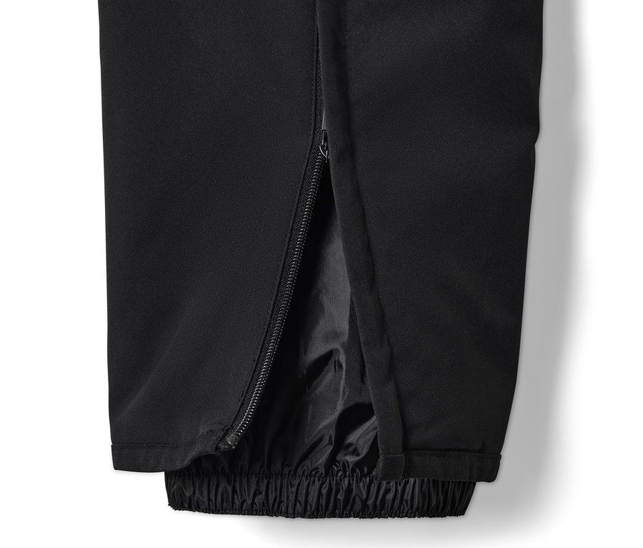 Egy fekete, high-tech férfi sínadrág részlete, cipzárral a száron.