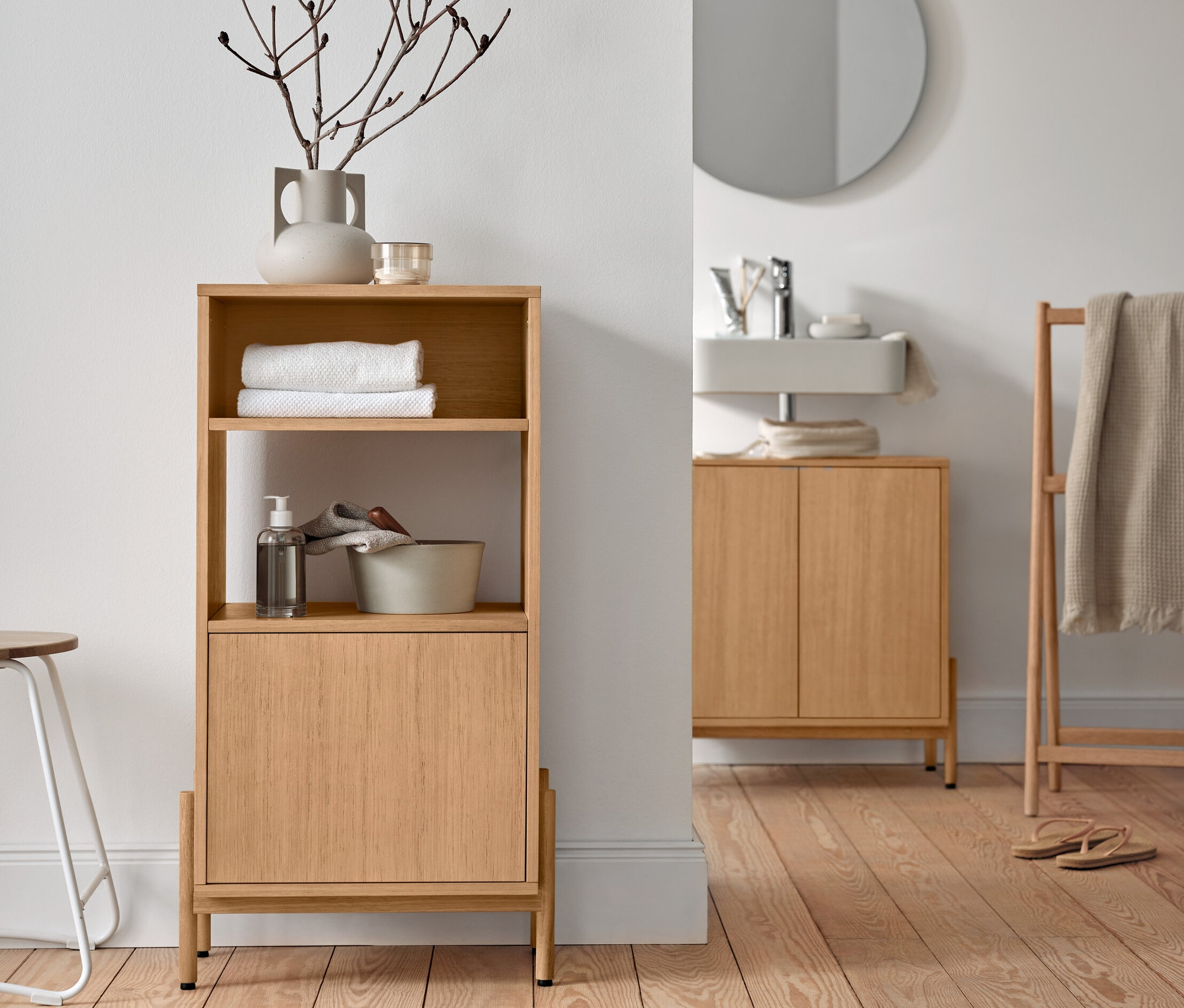 Fürdőszobaszekrény fafurnérral, mosdó alatti szekrény és törölközőtartó állvány a fürdőszobában.