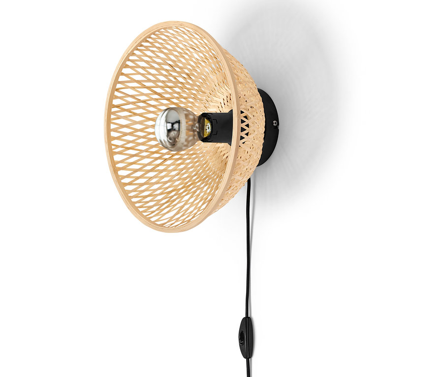 Fali lámpa bambusz lámpaernyővel egy fehér falon.