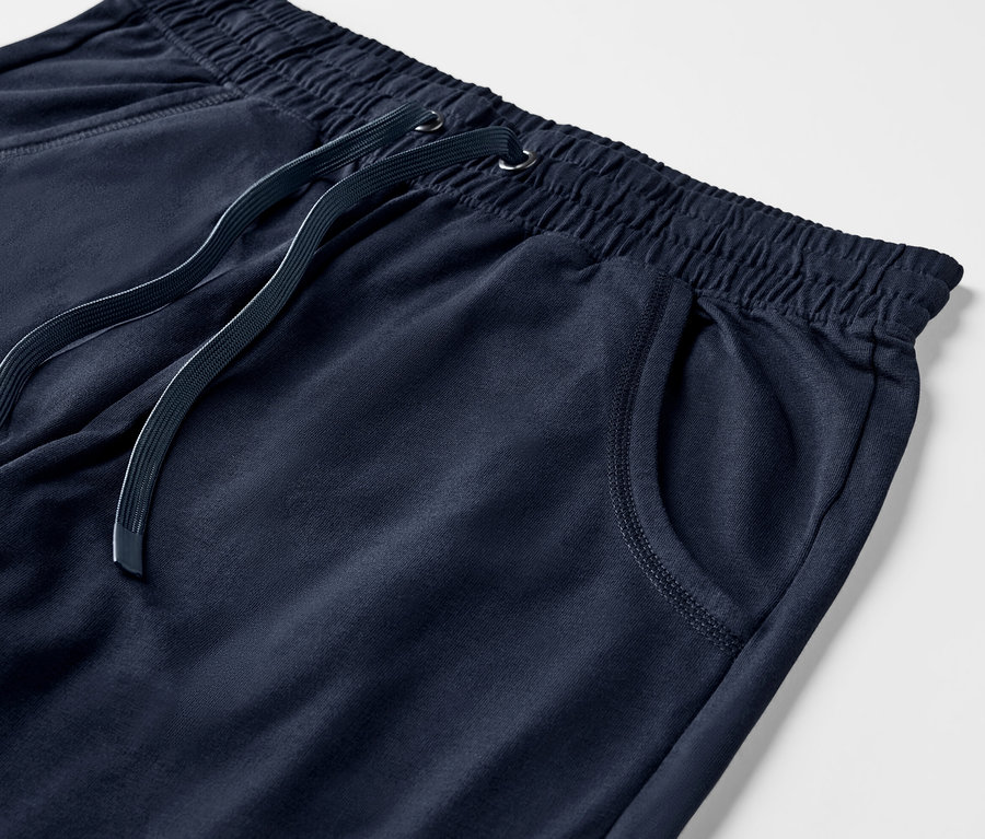 Egy sötétkék, 3/4-es melegítőnadrág részletes nézete, elasztikus derékpánttal és húzózsinórral.