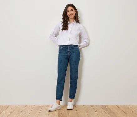 Nő áll és pózol kék Mom Jeans – Fit »Nyla« nadrágban.