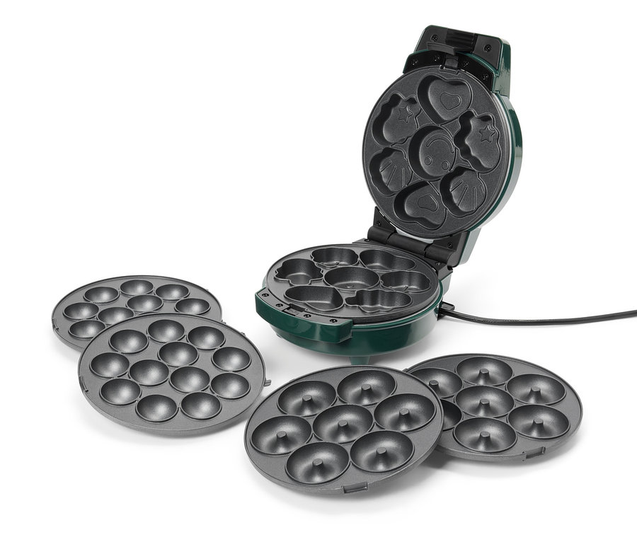 Egy zöld donut készítő van nyitva, különböző formákkal, beleértve a szívet, a csillagot és a mosolygós arcot. A készítőhöz négy szürke donut lemez tartozik.