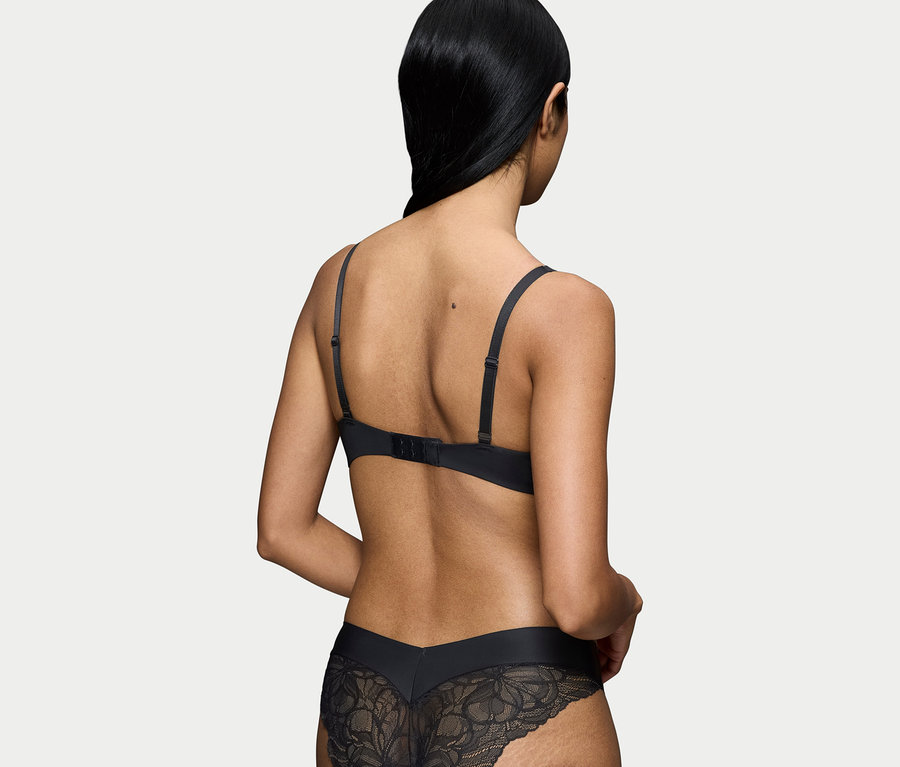 Hátulnézet egy fekete melltartót és csipkés alsóneműt viselő nőről.