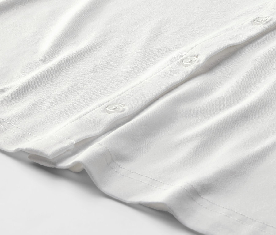 Egy fehér női pólóblúz részlete, gombos.