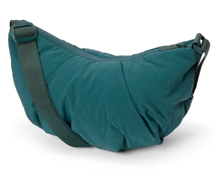 Egy zöld nylon válltáska közeli képe fehér háttérrel.