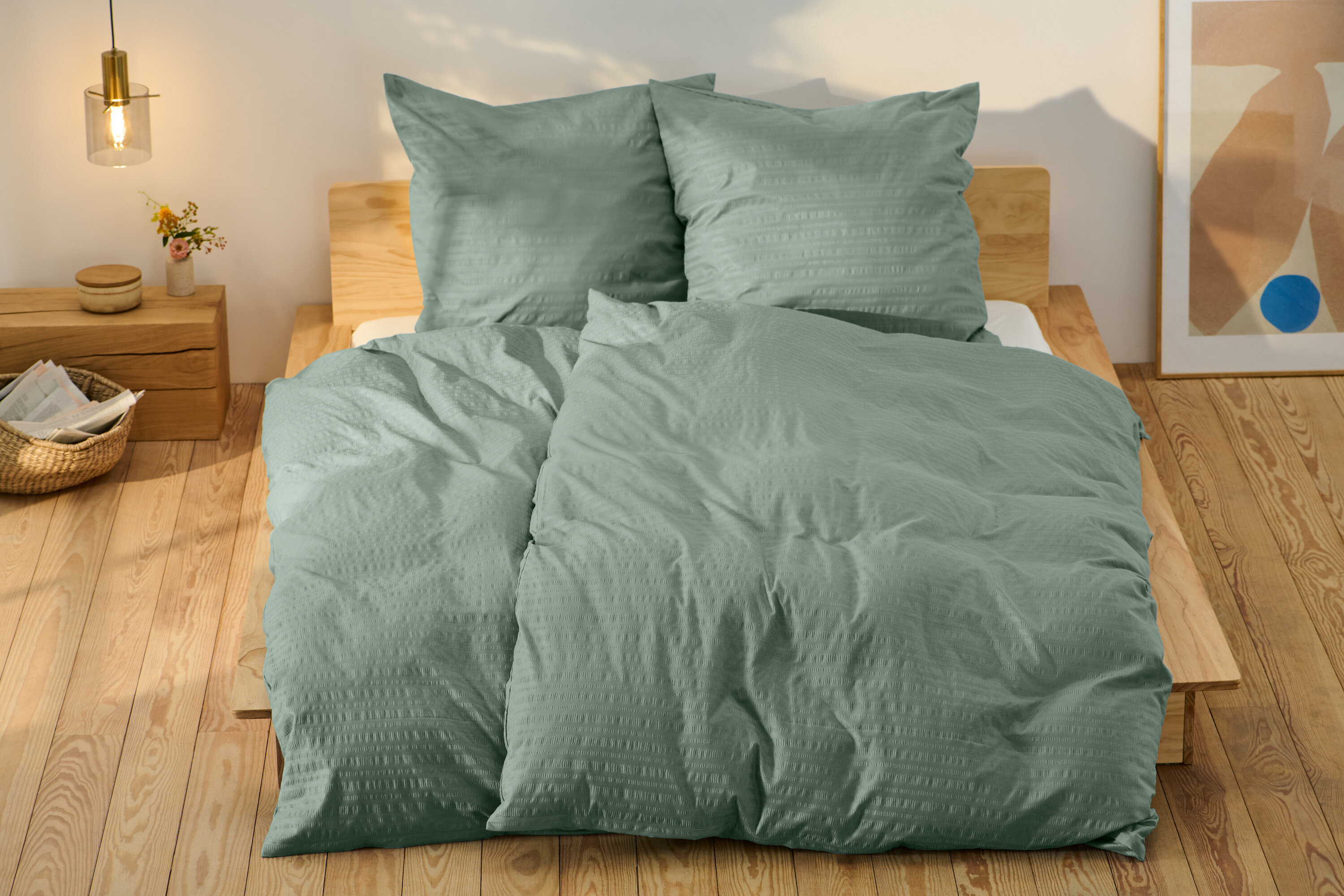 Zöld, normál méretű és egy extra méretű krepp ágynemű egy ágyon.