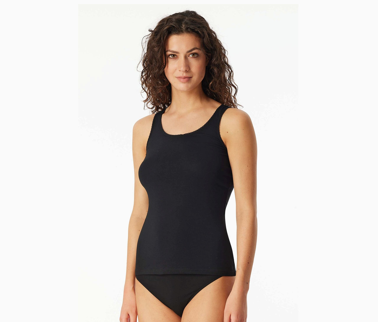 Hullámos hajú nő fekete trikót és fekete alsóneműt visel.