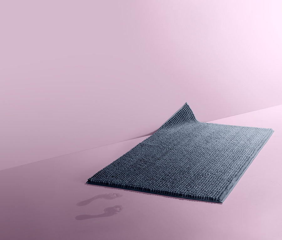 Egy körülbelül 70x120 cm-es kék kádkilépő egy rózsaszín felületen.