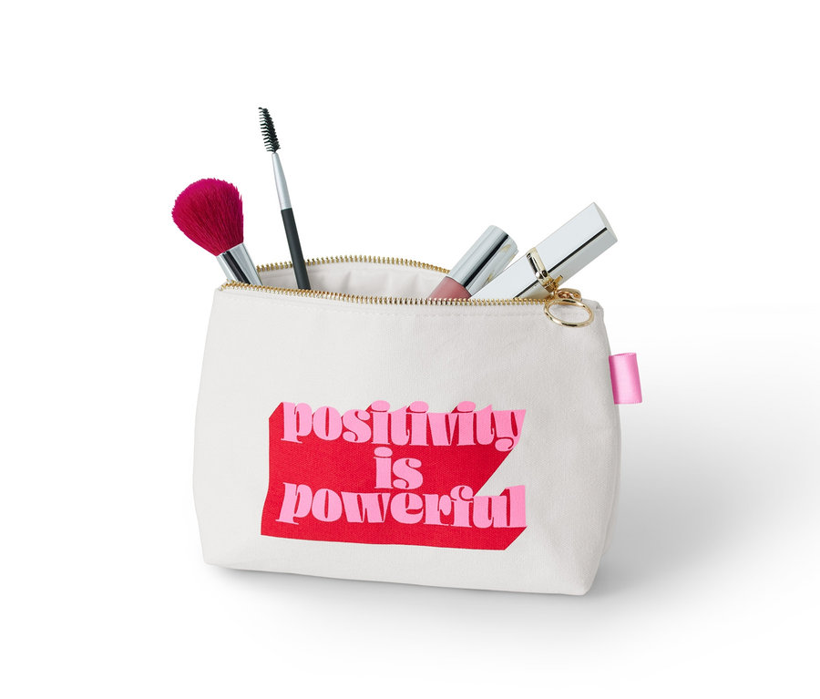 Egy "positivity is powerful" feliratú neszesszer sminkecsetekkel.