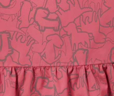 Egy gyermek termo esőkabát részlete fényvisszaverő elemekkel és állatmintával.