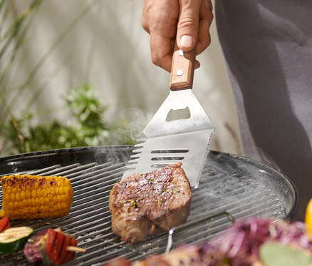 Férfi steaket grillez multifunkciós grillező eszközzel.