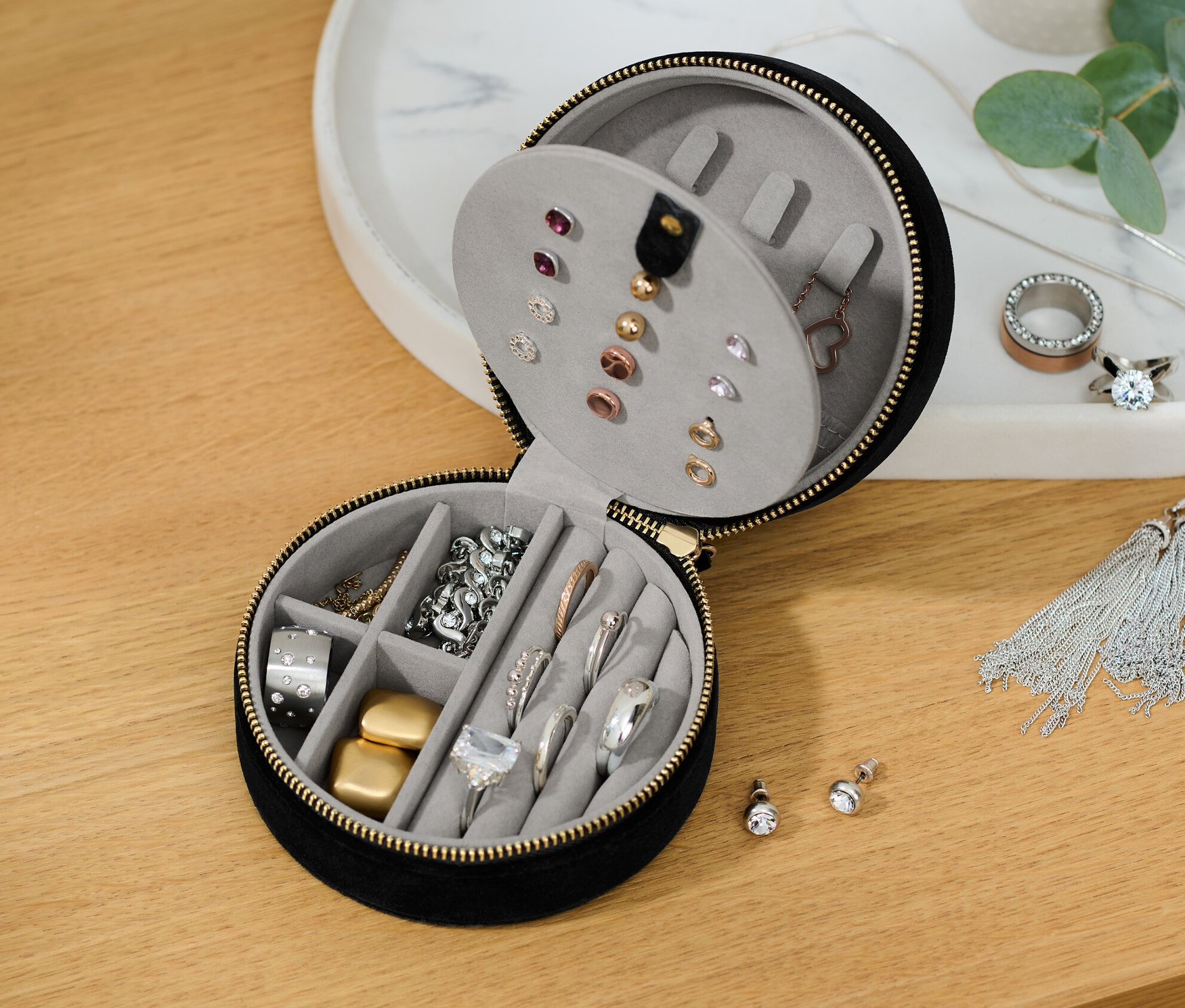 Egy részben nyitott ékszertartó doboz különféle ékszerekkel.