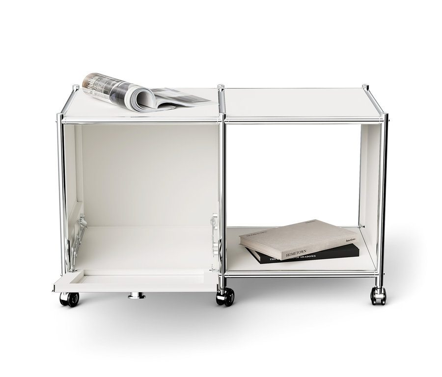 Fehér »CN3« fém kisasztal 1 lenyíló ajtóval, görgőkkel és újsággal a tetején.